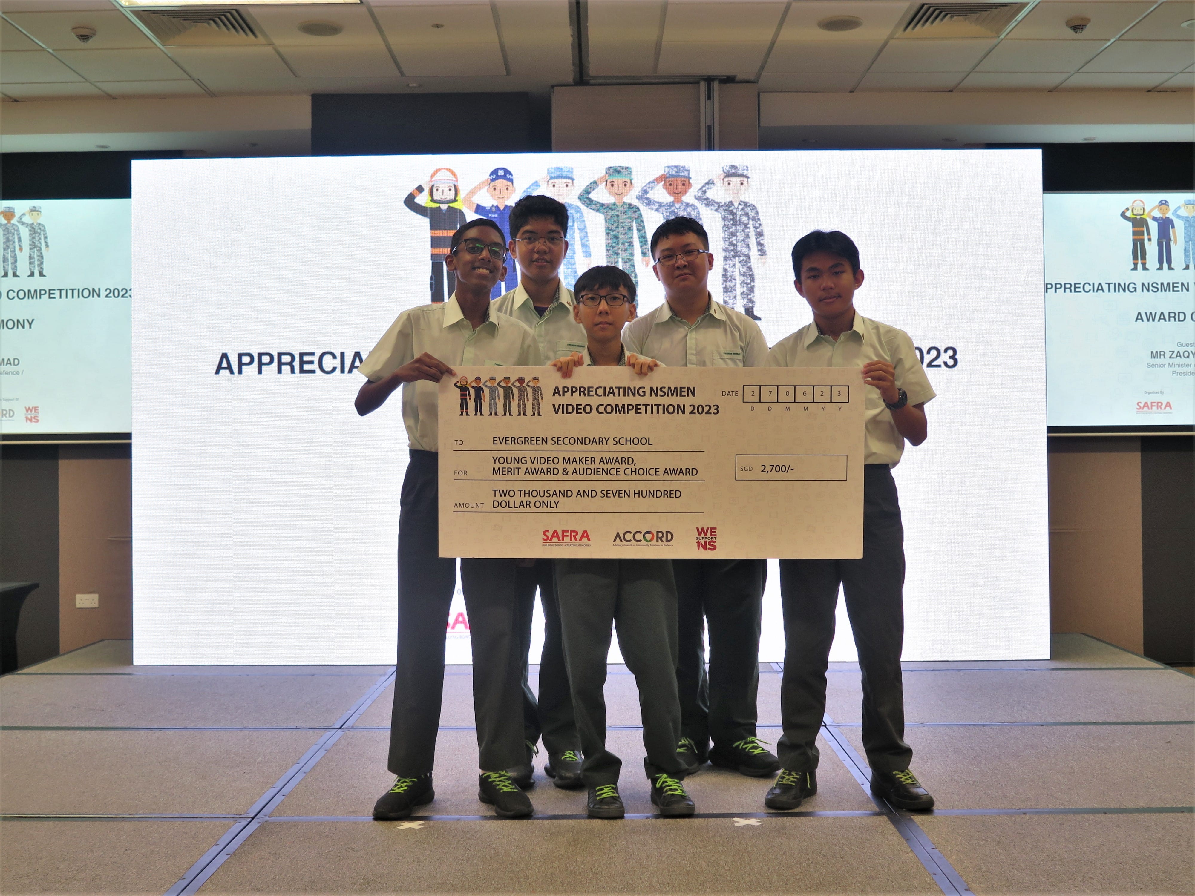 DMC members holding a large SGD 2,700 prize cheque from the Appreciating Nsmen Video Competition 2023.